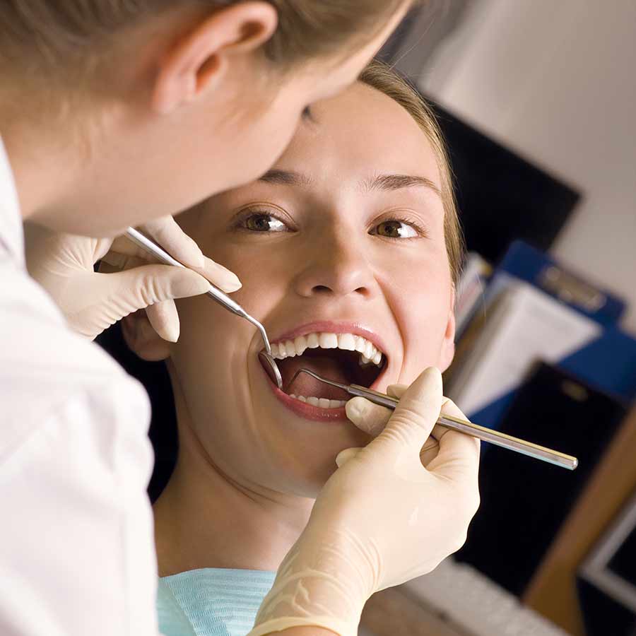 dental hygienist cleaning teeth